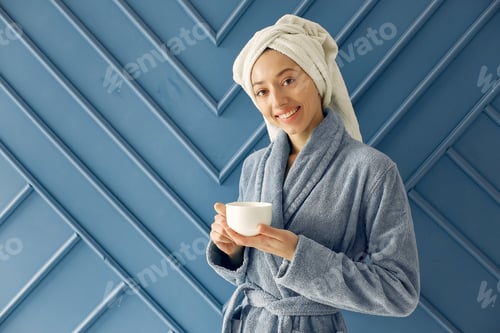 Preview: Beautiful girl standing in a studio in a blue bathrobe