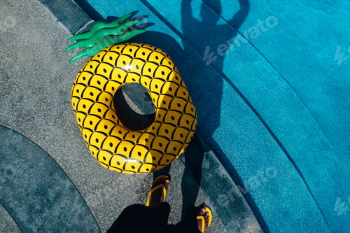 Preview: Yellow sandals and swim rings at the pool on a hot summer day