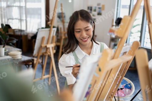 Preview: Asian woman is painting art. She is a professional artist. Watercolor artist is painting art on pape