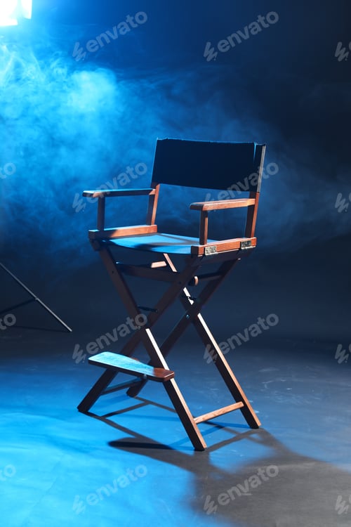 Preview: One empty director's chair on dark blue background with smoke