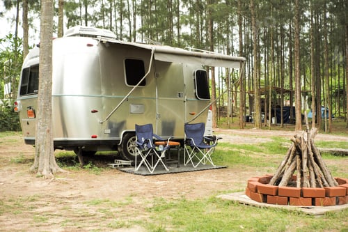 Preview: Classic caravan car parking in the outdoor park with forest of pine trees in background