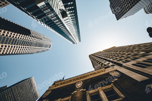 Preview: Low angle shot of skyscrapers and modern buildings in a city under the blue sky