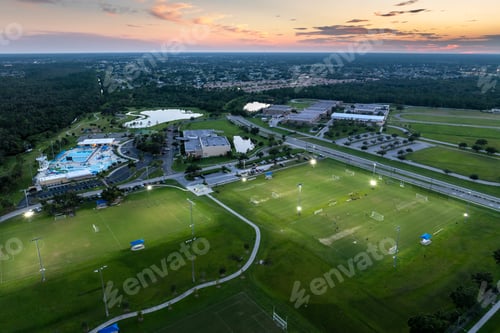 Preview: Public sports stadium with young people playing football game at sunset. Active way of life concept