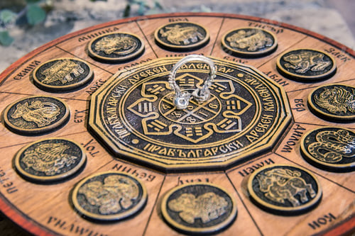 Preview: Shallow focus closeup shot of a skull septum piecing on an astrological calendar
