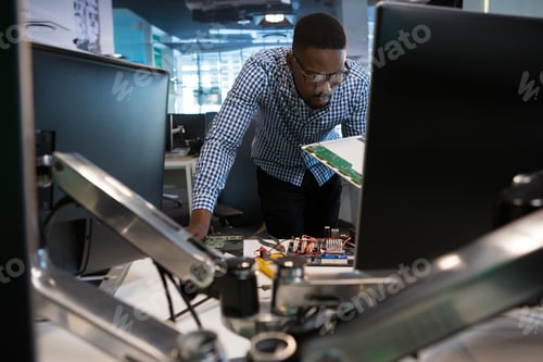 Preview: Computer engineer repairing motherboard at desk