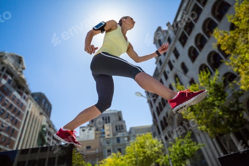 Preview: A beautiful woman jumping in the street on a sunny day