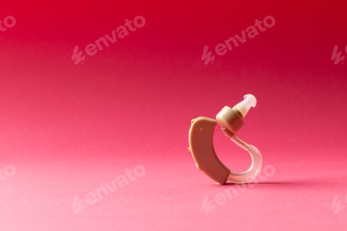 Preview: Composition of hearing aid on red background with copy space