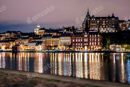 Preview: The Stockholm skyline, featuring illuminated buildings and their reflections in the dark water