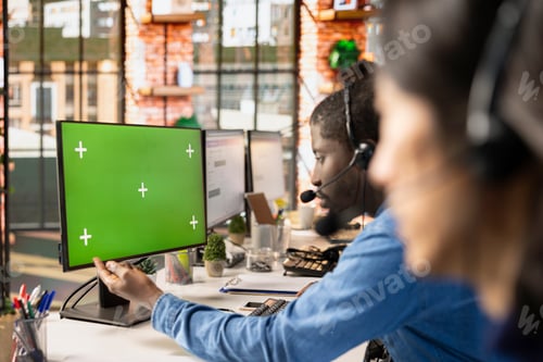 Preview: Call center agent at green screen PC answering customers technical inquiries