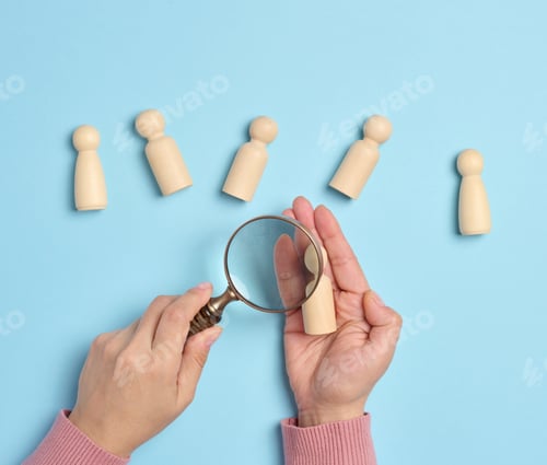 Preview: Wooden men and a magnifying glass on a blue background. Recruitment concept