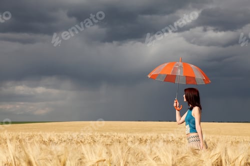 Preview: Girl with umbrella at wheat field at rainy day