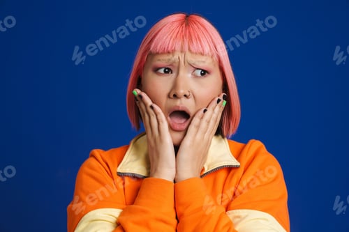 Preview: Asian girl with pink hair and piercing expressing surprise at camera