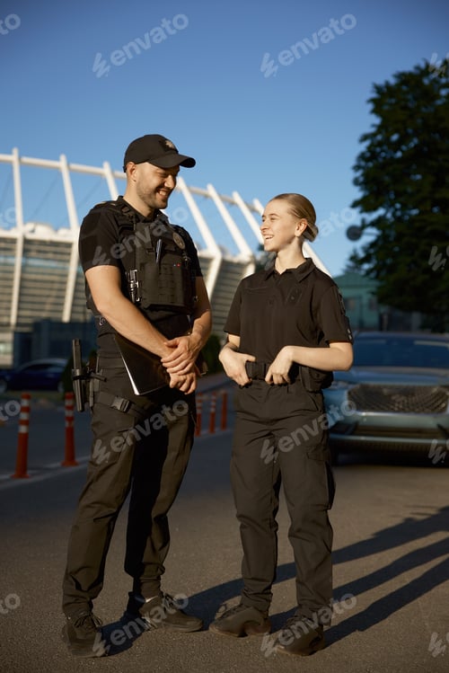 Preview: Friendly smiling patrol police officers outdoor