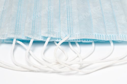 Preview: Close-Up Lot of Medical Surgical Face Masks with Rubber Ear Straps on White Background. Concept