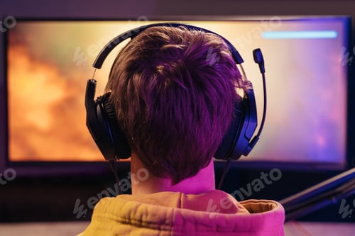 Preview: Man cyber sportsman looking at monitor while gaming shooting video game