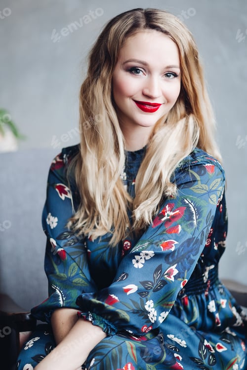Preview: Beautiful female model in dark blue dress sitting on wooden stairs