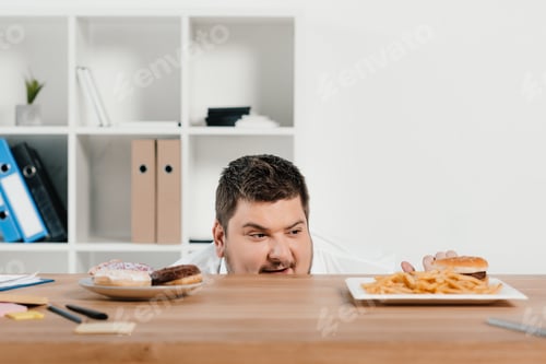 Preview: hungry fat businessman choosing donuts or hamburger with french fries for lunch