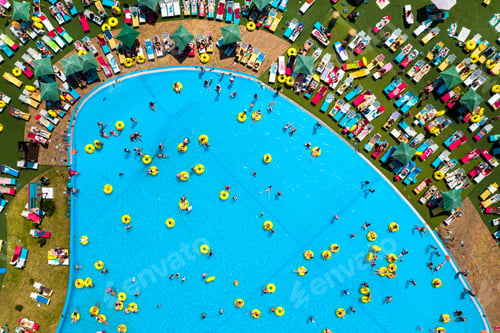 Preview: Top view of people relaxing in the pool on yellow inflatable circles and sun beds on the beach