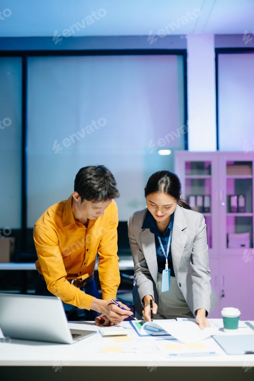 Preview: Asian business colleagues collaborating in modern office, discussing documents and strategy,