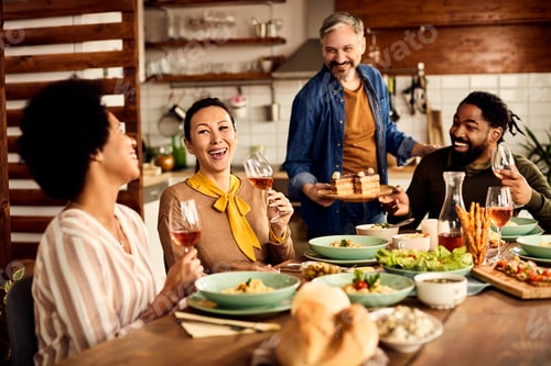 Preview: Multi-ethic group of friends having fun during a meal at dining table.