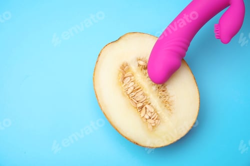 Preview: Half of melon and purple vibrator on blue background, flat lay with space for text. Sex concept