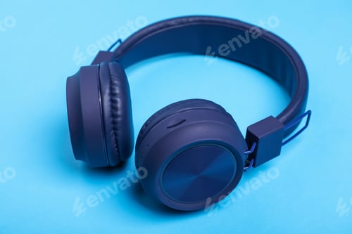 Preview: Pair of stylish headphones on light blue background, closeup