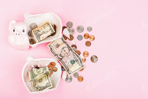 Preview: Broken piggy bank with cash money dollar bills and coins on pink background