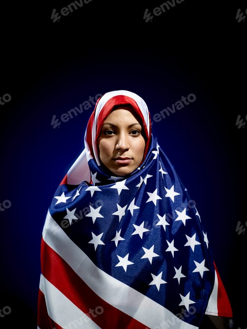Preview: A woman draped in an American flag hijab stands against a dark background