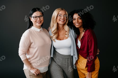 Preview: Three happy mature women bonding and smiling against grey background