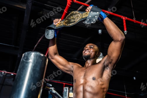 Preview: African muscular boxer raises his arms after win tournament on stage.