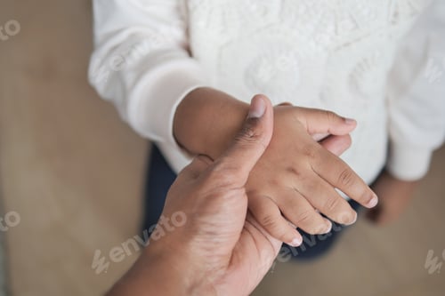 Preview: father holding hand of baby child, close up .