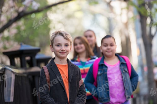 Preview: A group of children on the sidewalk, carrying bags.