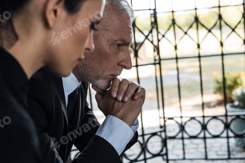 Preview: selective focus of senior man with clenched hands near woman on funeral