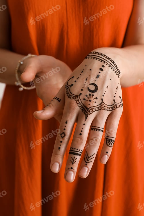 Preview: Woman with henna tattoo on hand, closeup. Traditional mehndi ornament