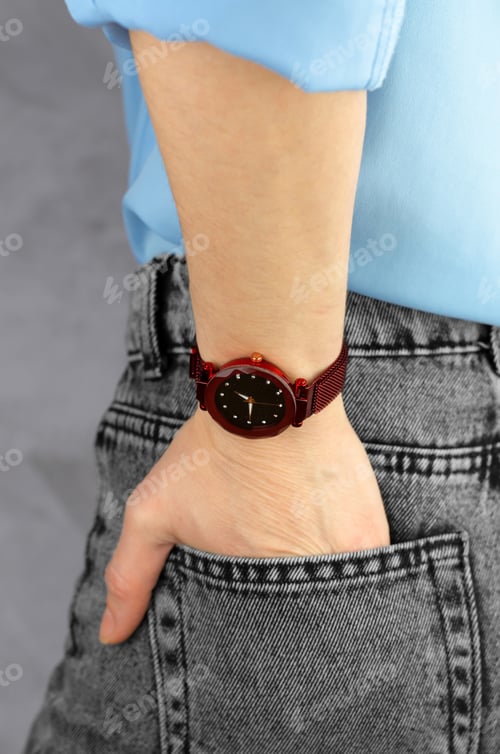 Preview: Beautiful burgundy wrist watch on a female hand, close-up