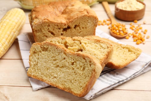 Preview: Freshly baked cornbread, cobs and seeds on wooden table, closeup