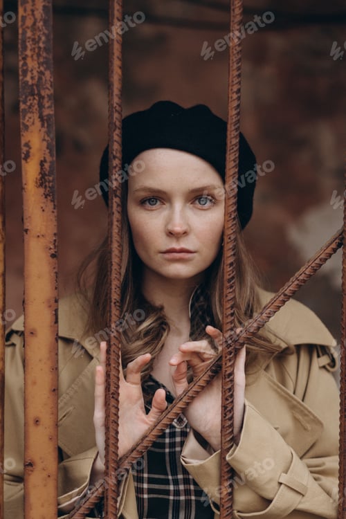 Woman with Black Beret Behind Rusted Metal Bars