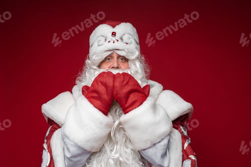 Preview: Father Frost with hands by mouth looking at camera.