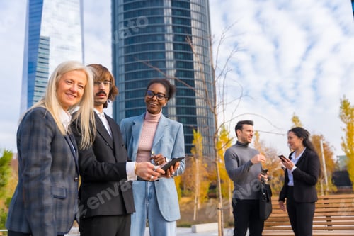 Preview: Multi-ethnic business colleagues or executives, looking at technologies and talking about work