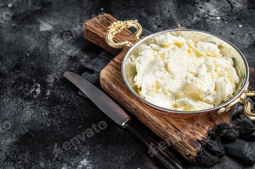 Preview: Kaymak Clotted cream, butter cream in a rustic pan. Black background. Top view. Copy space