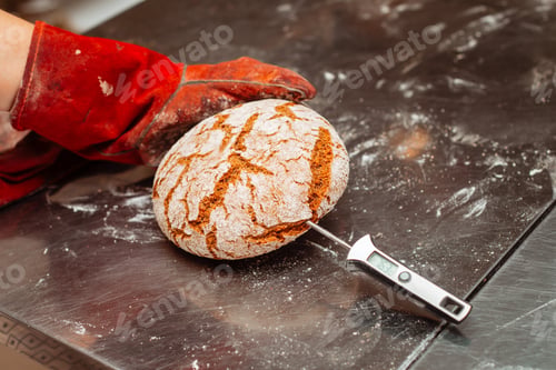 Preview: the baker measures the temperature of the finished baked bread