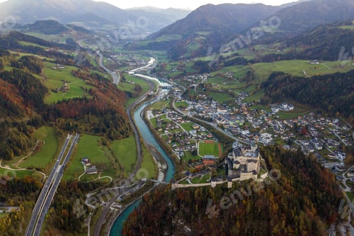 Preview: Aerial view of green meadows with villages and forest in austrian Alps mountains