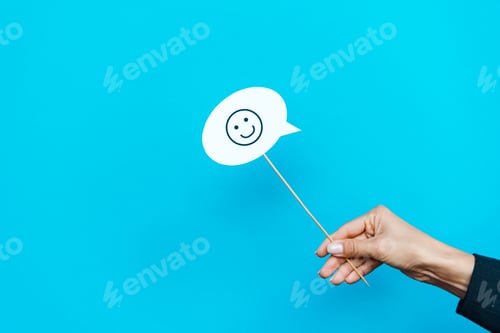 Preview: KYIV, UKRAINE - AUGUST 5, 2019: cropped view of woman holding stick with happy face on blue