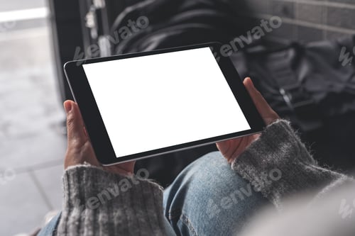 Preview: A woman holding and using black tablet pc with blank white desktop screen with baggages