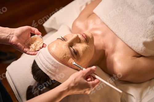 Preview: Qualified cosmetologist carrying out cosmetic procedure on adult woman