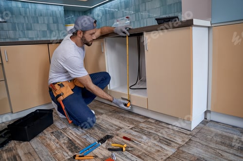 Preview: Young man measuring height of kitchen drawer