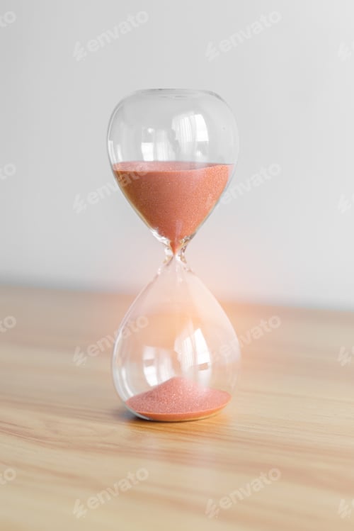 Preview: Hourglass on table, Sand flowing through the bulb of Sandglass