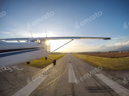 Preview: Small airplane taking off the runway during a vibrant sunset