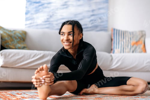 Preview: Sporty and flexible pretty African-American girl dressed in sportswear, is engaged fitness