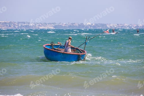 Preview: back view of fisherman in round boat floating on waves, Vietnam, Mui Ne